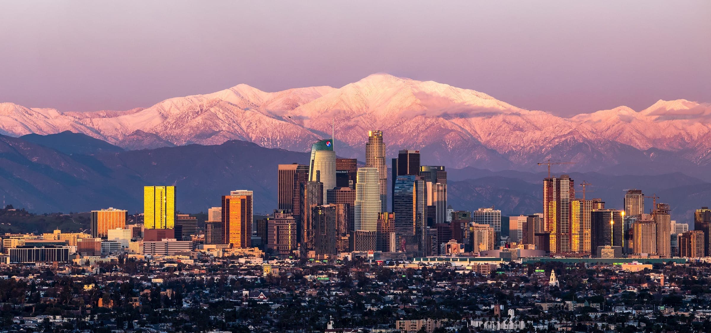 Centro de Los Ángeles al atardecer con el monte Baldy nevado