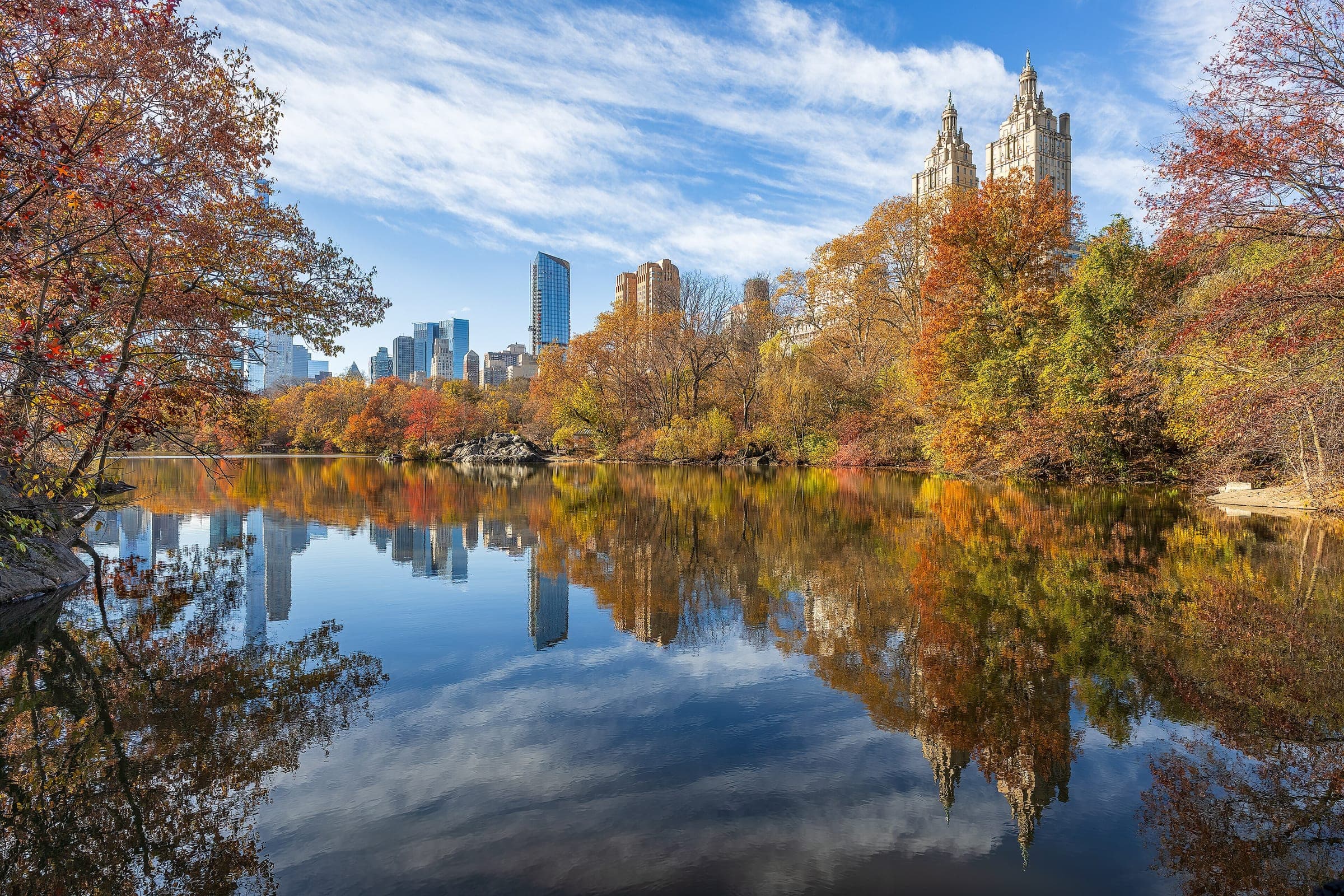 Central Park en otoño reflejado en el lago, con los edificios al fondo